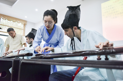 6月21日,古乐老师在教来自塔吉克斯坦 的留学生Umar(乌马尔)弹古琴。李谌涵 摄 6月21日,古乐老师在教来自塔吉克斯坦 的留学生Umar(乌马尔)弹古琴。李谌涵 摄